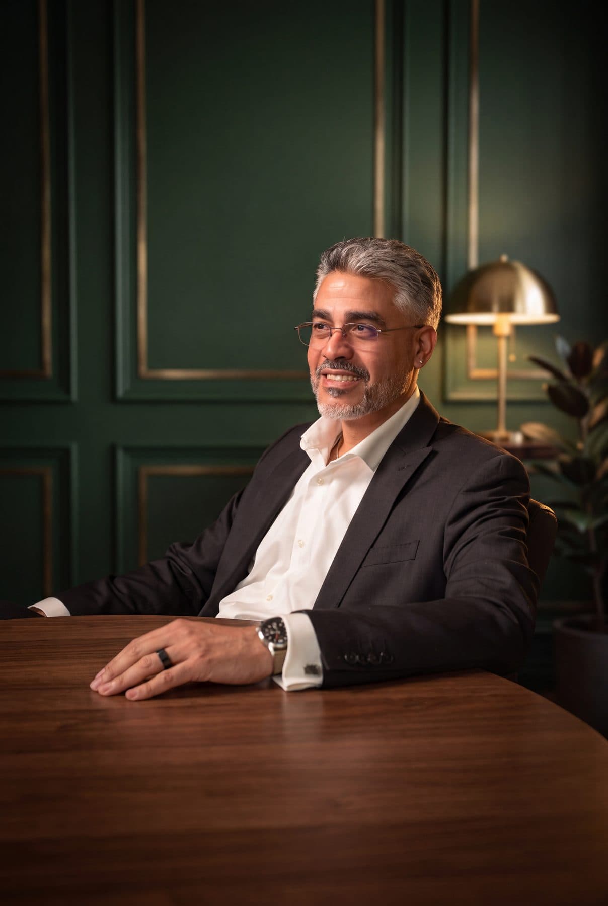Rafael Sánchez of RSCCA seated at a walnut table, turned toward the window and smiling.