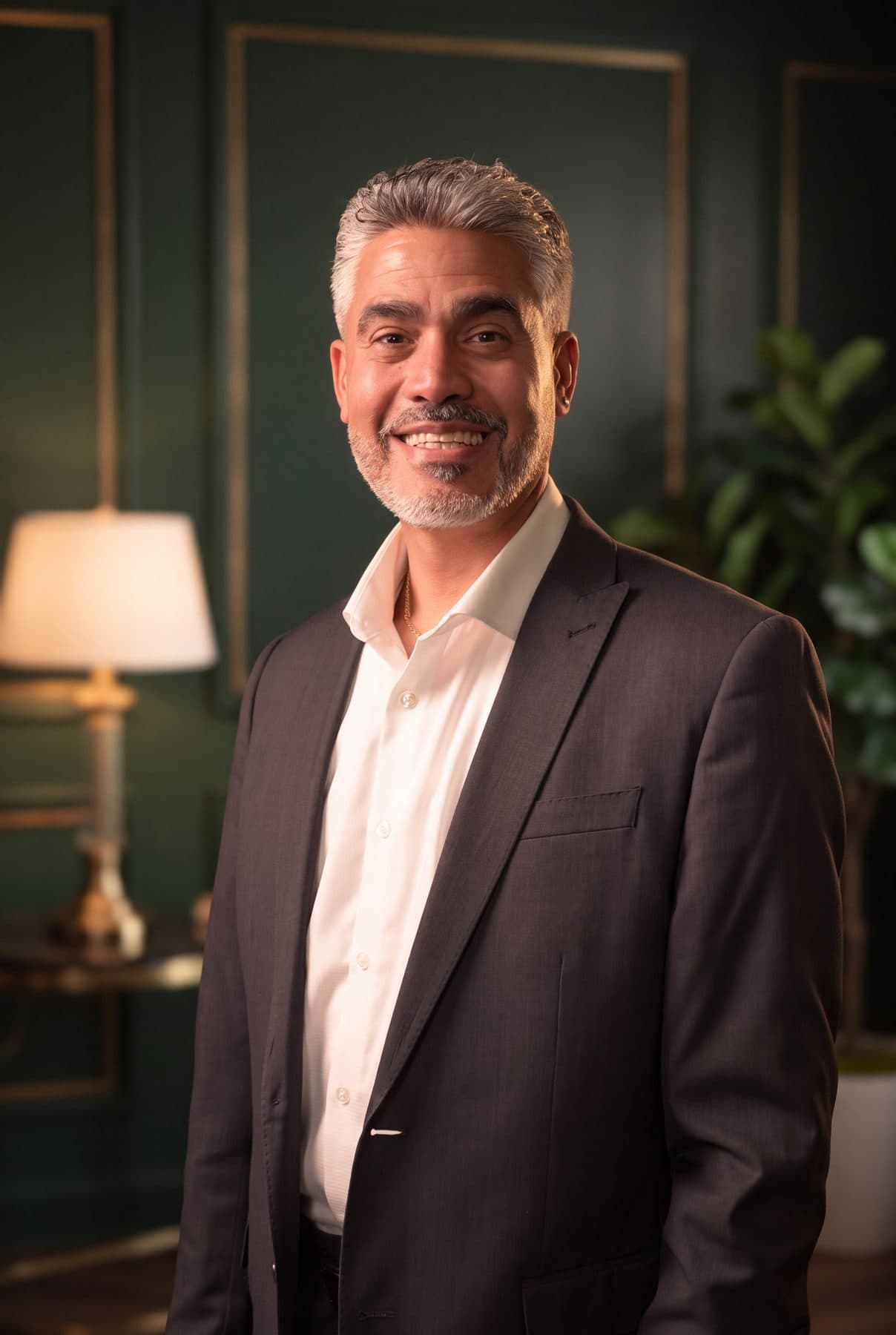 Rafael Sánchez of RSCCA, smiling, in a charcoal suit and open white shirt.