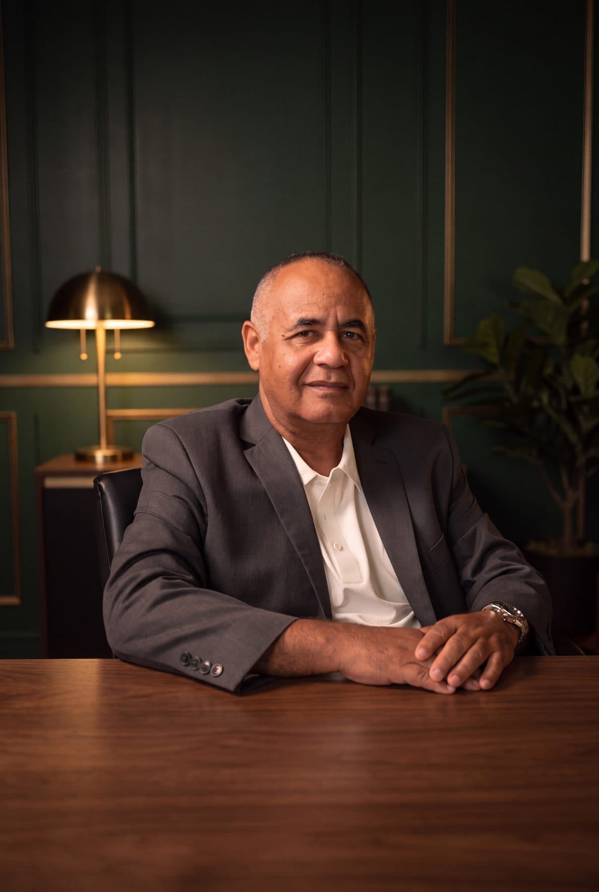 Ruben Rodriguez of RSCCA seated at a walnut table under a brass lamp.
