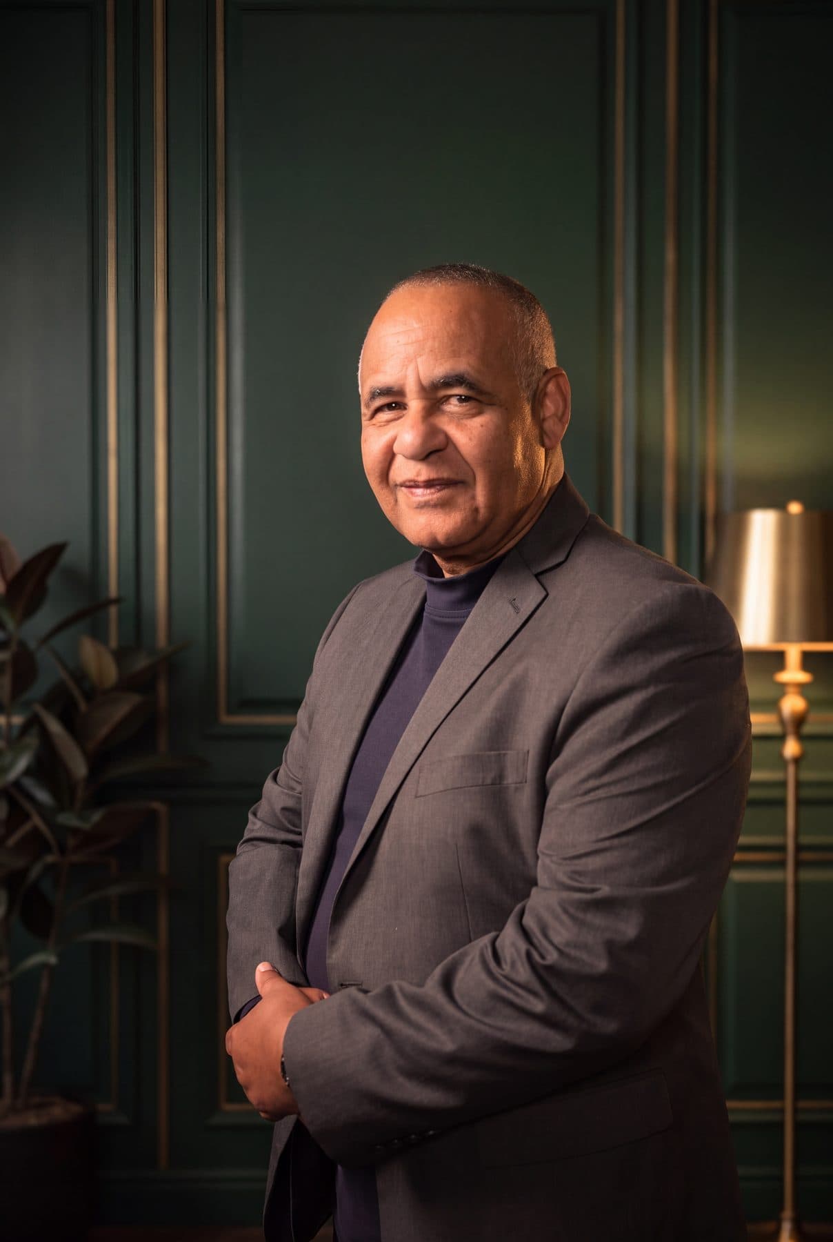 Ruben Rodriguez of RSCCA standing with his arms folded, in a grey jacket over a navy turtleneck.