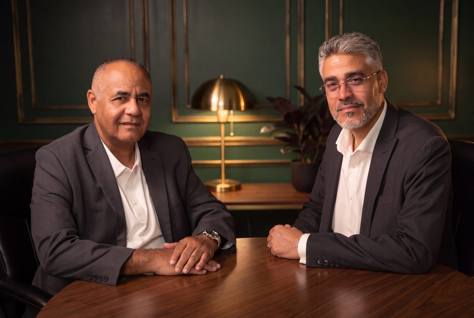 Ruben Rodriguez and Rafael Sánchez, the co-founders of RSCCA, seated together at a walnut table.